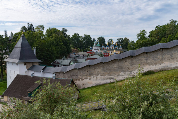 Sakristei, Glockenturm, Uspenski-Kathedrale (Mariä Himmelfahrt) im Pskov-Höhlen-Kloster hinter der Festungsmauer. Petschory, Russland - Foto, Bild