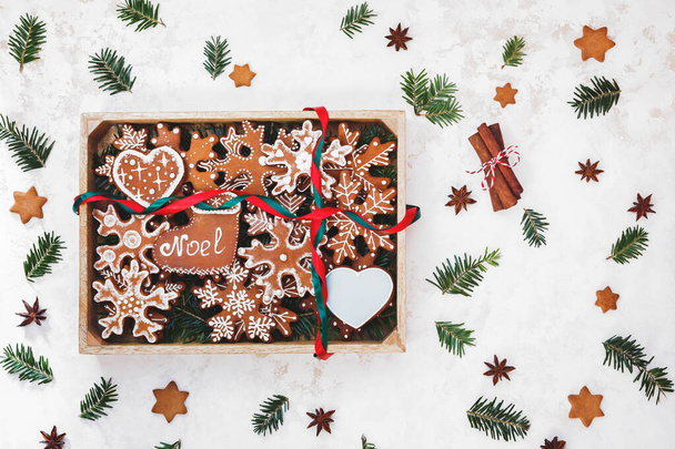 Gingerbread cookies placed in wooden box with red and green ribbon on top. Top view, blank space - Фото, изображение