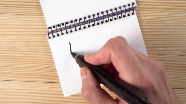 Työtön mies kirjoittaa NEED WORK muistikirjaan mustalla huopakynällä puupöydällä. Talouskriisin ja sepelvaltimotautiepidemian aiheuttaman työttömyyden käsite - Materiaali, video