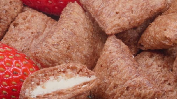 Leckeres trockenes Frühstück. Schokoladenkissen mit Füllung und frischen Erdbeeren in Nahaufnahme. - Filmmaterial, Video