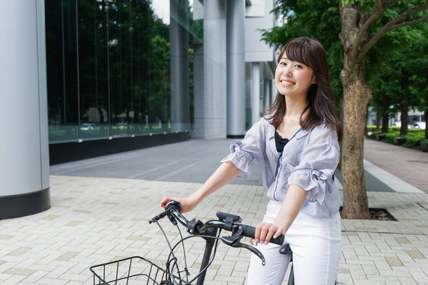 jong aziatische vrouw rijden op fiets - Foto, afbeelding