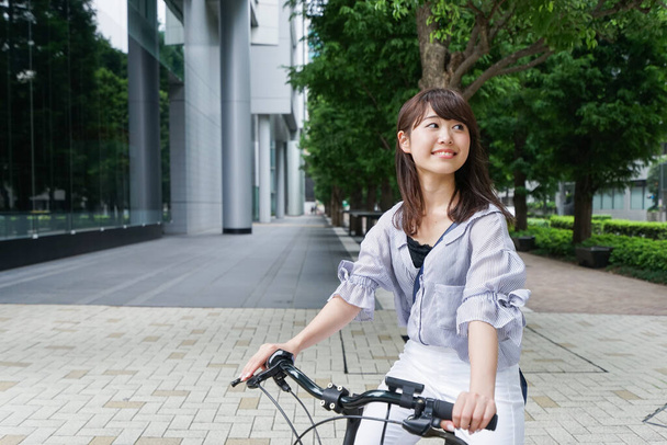 jong aziatische vrouw rijden op fiets - Foto, afbeelding