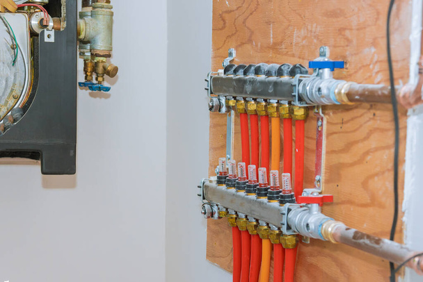 Tubos en distribuidor de calefacción central de calefacción central con válvulas rojas - Foto, Imagen