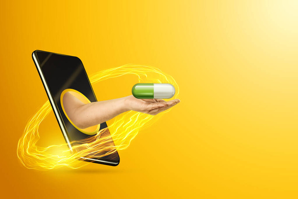 Hand delivers tablets, pills through a smartphone on a yellow background. Online health care concept, online ordering of medicines, modern medicine - Foto, Imagen
