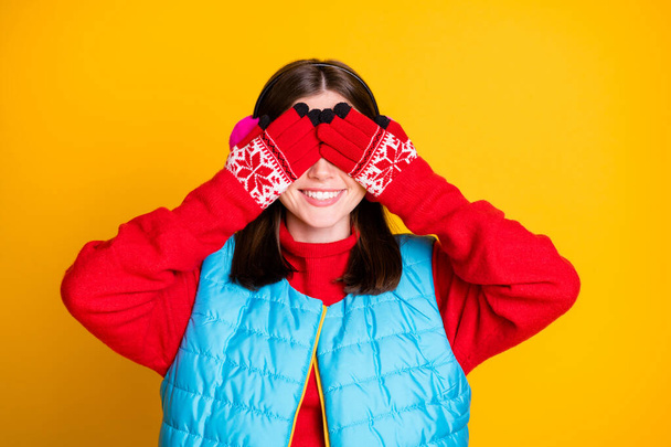 Photo of positive cheerful girl close cover face hands mittens eyes wait her boyfriend give her noel gift secret present wear winter season clothes isolated over shine color background - Foto, afbeelding