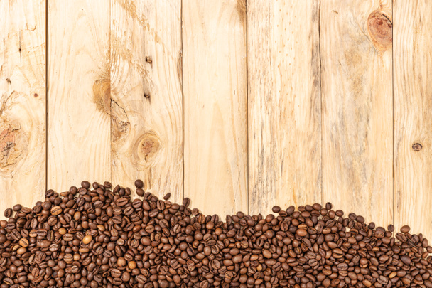 木の板の上で豆をロースト背景。コーヒー壁紙。コピースペース。トップ表示 - 写真・画像