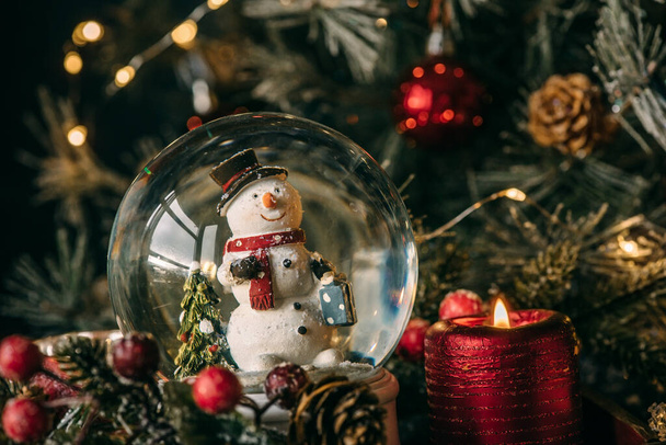 Christmas card with Snow crystal ball, snowman and candle - Photo, Image