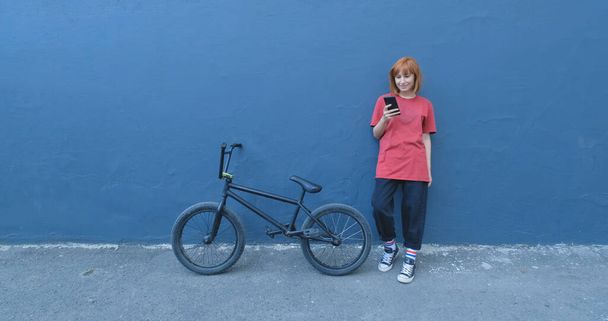 Young woman posing with BMX bicycle outdoor on the street  - Foto, Imagen