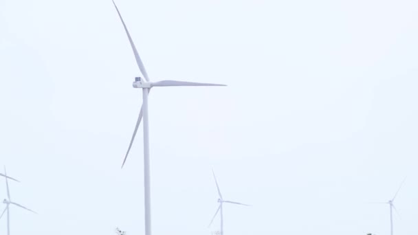 灰色の空のスローモーション映像で回転する風力発電機のクローズアップ。田舎の未来のグリーンエコエネルギー。ウクライナのタービン、発電 - 映像、動画
