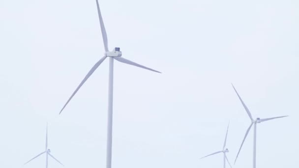 Větrné elektro generátory farma close-up rotující na šedé obloze smyčka záběry. Zelená eko energie budoucnosti na venkově. Ukrajinské turbíny, výroba elektřiny - Záběry, video