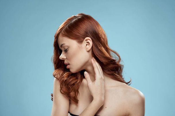 Красивая женщина кудрявые длинные волосы гладкая прическа голые плечи косметика ухода синий фон - Фото, изображение