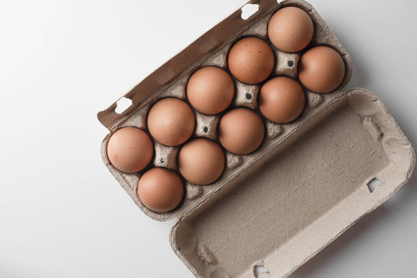 Many fresh raw chicken brown eggs in cartons as background, top view. Place for text - Foto, Imagem