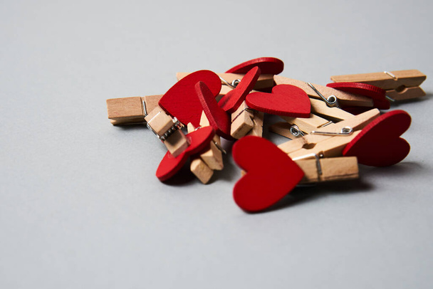 Pinzas de tela con corazones de madera al final sobre un fondo gris Decoración de San Valentín - Foto, imagen