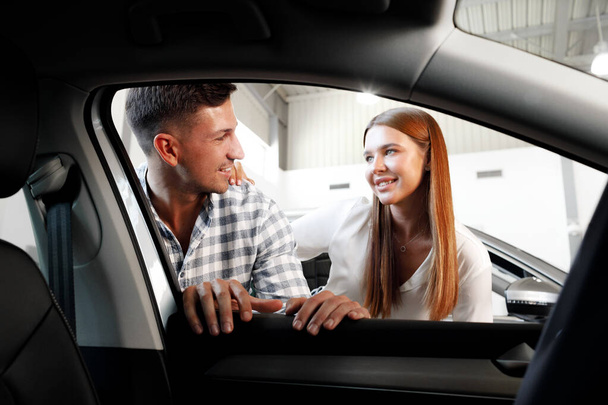 Young couple choosing their new car in a car shop - Foto, Imagem