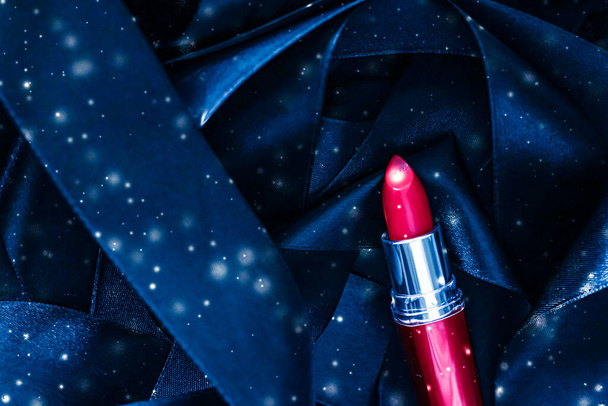 青い絹と光沢のある輝きの背景に赤い口紅、豪華な化粧品と美しさの化粧品 - 写真・画像