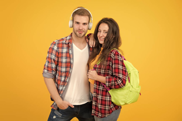 trendy dressed students. back to school. People lifestyle concept. university student dating. Two cheerful students. study together. girl carry backpack. man listen music in headset. feeling carefree - Photo, Image