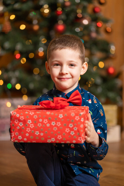 Christmas fabulous, little boy holding a big red box with a present from Santa. - Photo, image