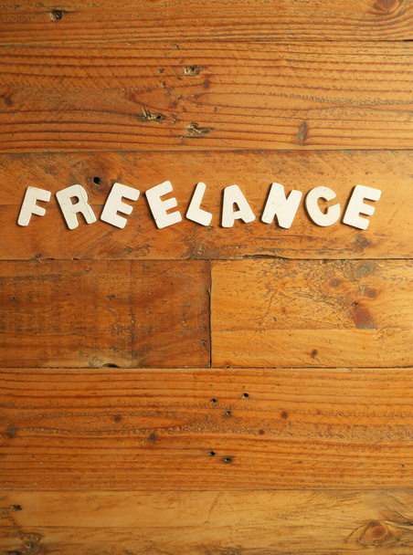 Slovo FREELANCE bílými písmeny na dřevěném pozadí - Fotografie, Obrázek