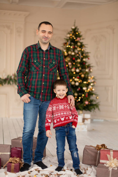 Smiling father hug his son at Christmas tree, surrrounded presents. Happy family holidays - Foto, immagini