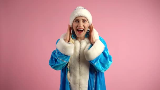 Usmívající se žena v modrém kostýmu sněhové panny tleskající šťastně rukama, rozradostněná a vzrušená žena ukazující upřímné emoce na kameře na izolovaném růžovém pozadí. Šťastná sněhová panna ukazuje vítěze - Záběry, video