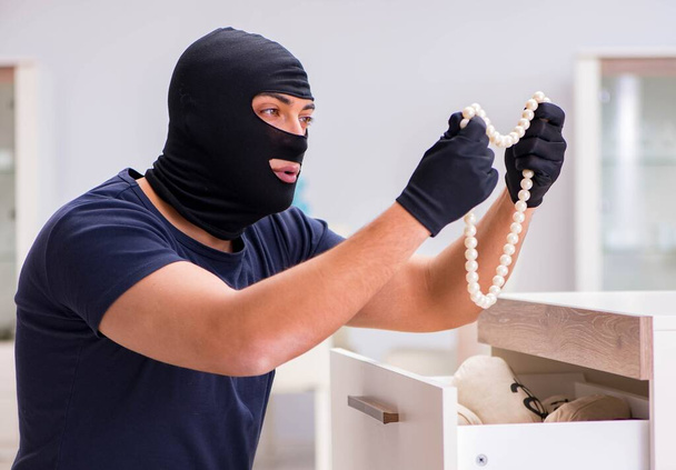 Ladrón con pasamontañas robando cosas valiosas - Foto, imagen