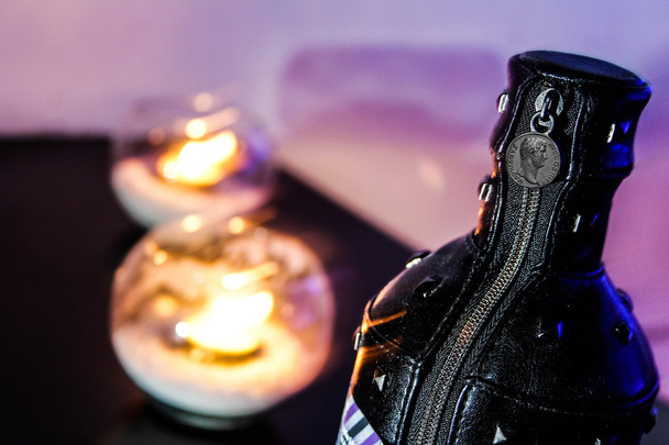 Flaschenetui aus Leder neben zwei Kerzen - Foto, Bild