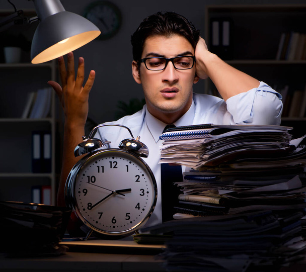 Joven hombre de negocios trabajando horas extras hasta tarde en el cargo - Foto, imagen