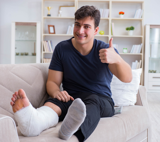 Man with broken leg recovering at home - 写真・画像