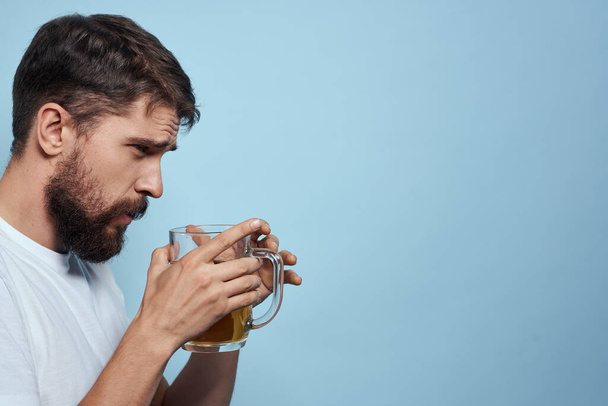 pijany człowiek piwo kubek zabawa biały t-shirt styl życia niebieski tło - Zdjęcie, obraz