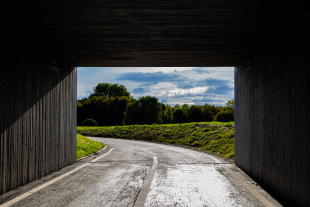 Licht und Landschaft am Ende eines dunklen quadratischen Tunnels - Foto, Bild