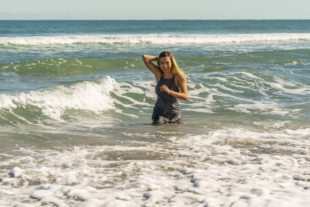 A gorgeous young blonde female enjoys a day at the beach alone - Фото, зображення