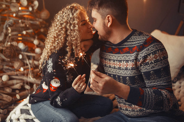 Elegant couple sitting at home near christmas tree - Фото, зображення