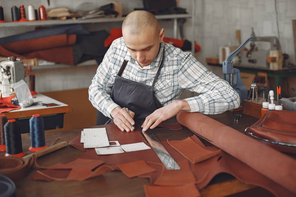 Man in a studio creates leather ware - Φωτογραφία, εικόνα