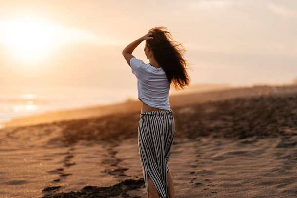 Happy Woman Enjoying Beautiful Sunset on the Beach - Photo, Image