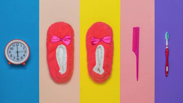 Zapatillas, peine, reloj y cepillo de dientes sobre un fondo multicolor. - Foto, imagen