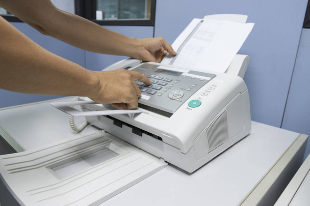 Hand Mann verwenden ein Faxgerät im Büro, Ausrüstung für die Datenübertragung. - Foto, Bild