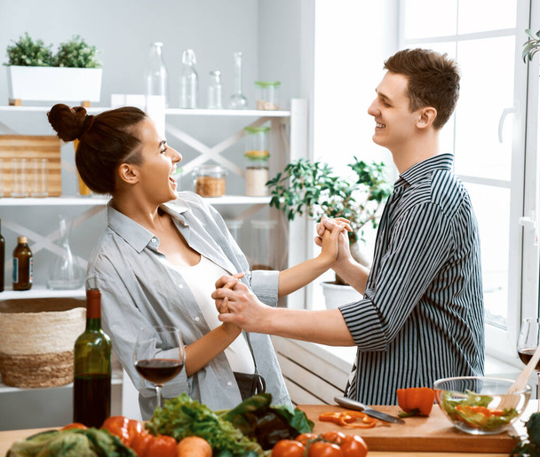 Healthy food at home. Happy loving couple is preparing the proper meal in the kitchen. - Foto, Imagem