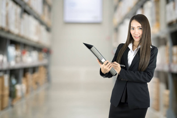 Asian businesswoman checking list order on a warehouse. - Photo, image