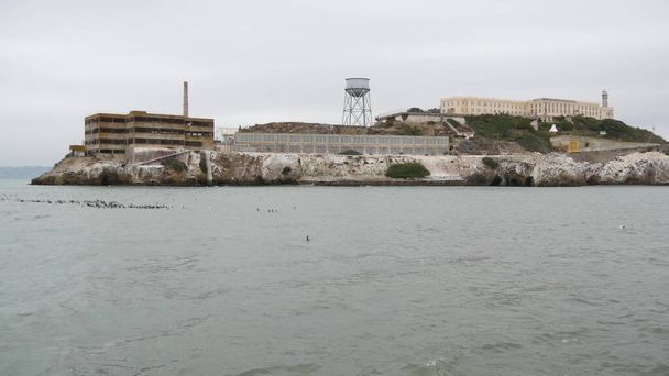 Ostrov Alcatraz v San Francisco Bay, Kalifornie USA. Federální vězení pro gangstery na skále, zamlžené počasí. Historické vězení, útes v zamlženém zamračeném přístavu. Gaol za trest a uvěznění za zločin. - Fotografie, Obrázek