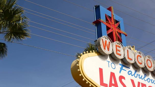 Welcome to fabulous Las Vegas retro neon sign in gambling tourist resort, USA. Iconic vintage banner as symbol of casino, games of chance, money playing and hazard betting. Lettering on signboard. - Photo, Image