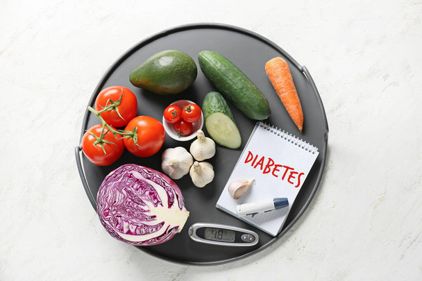 Zöldségek, notebook szöveges DIABETES, Lancet toll és glucometer fehér alapon - Fotó, kép