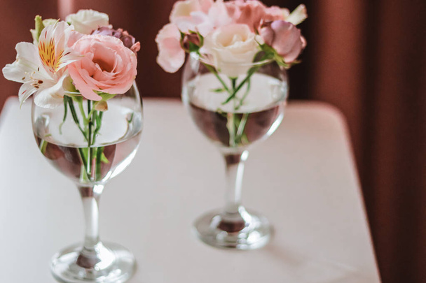 Cut flowers in glasses of water. Mini composition for table decoration. - Photo, Image