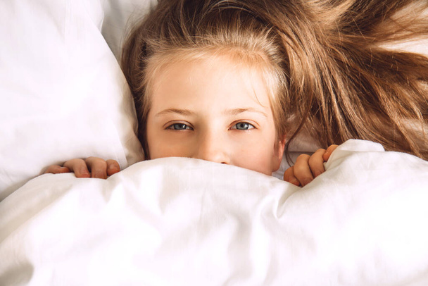 Niño escondido bajo edredón en la cama - Foto, Imagen
