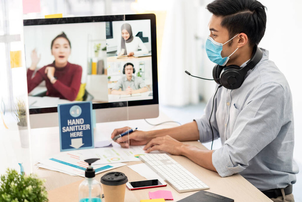 Asian businessman work from home office involved video conference meeting with corporate colleague for discuss and brainstorm distantly. This technology is popular after coronavirus COVID-19 spreading - Fotoğraf, Görsel