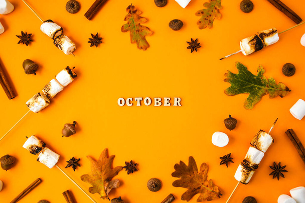 OCTOBER text . Cinnamon marshmallows leaves and anise on yellow background. Fall composition. Pattern made of autumn things. Flat lay. Ornament For Thanksgiving. Autumn Frame with Copy space. - Φωτογραφία, εικόνα
