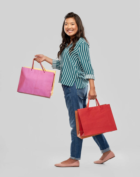 happy asian woman walking with shopping bags - Фото, зображення