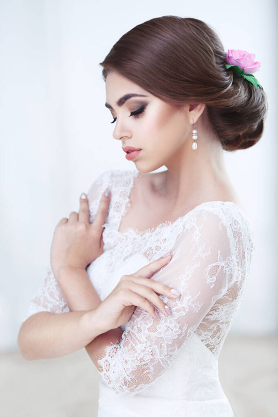 Portrait of a beautiful brunette bride bright makeup and hairstyle in lace dress - Zdjęcie, obraz