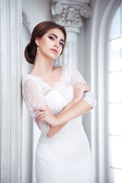 Portrait of an elegant brunette bride is in a luxury hall with columns - Photo, Image