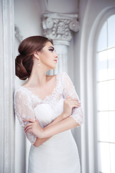 Portrait of an elegant brunette bride is in a luxury hall with columns - Photo, Image