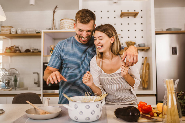 молодая пара готовит вместе на кухне - Фото, изображение